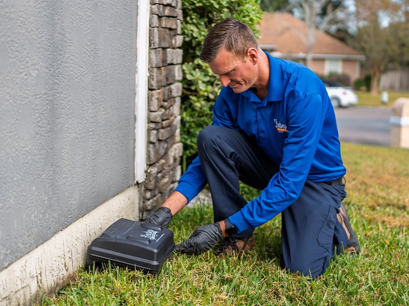 pest control specialist checking rodent station