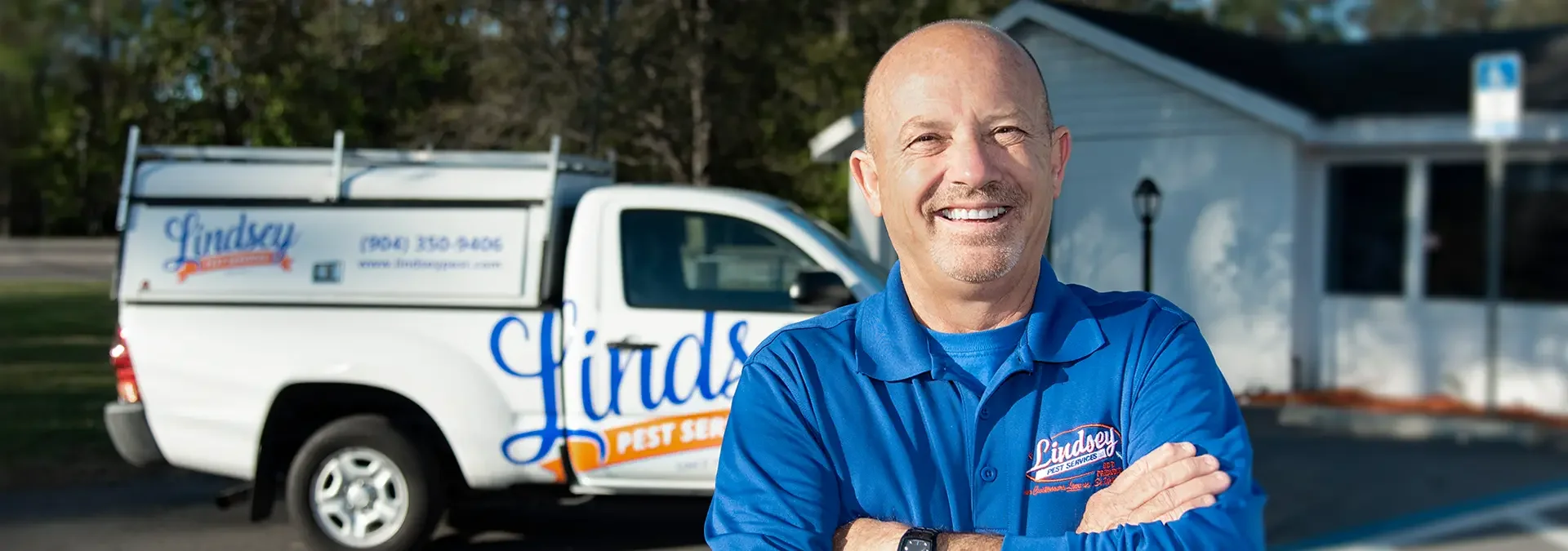 lindsey technician standing in front of a pest control vehicle