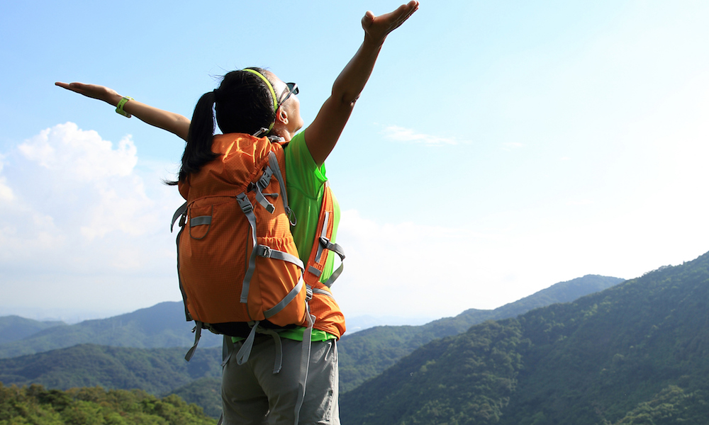 Woman looking up at the sky with her hands up