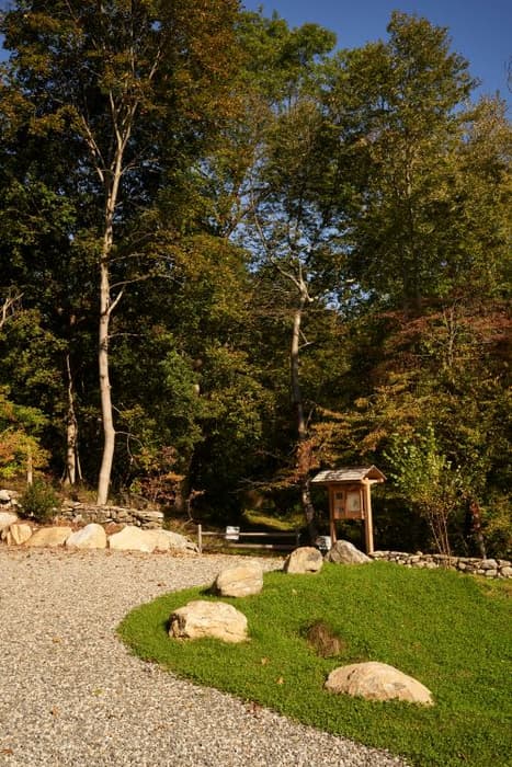 gravel parking area, trail entrance and sign