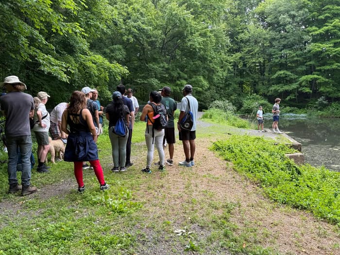 a group of hikers gathered on a path near a pond (Credit: Alan Baglia)