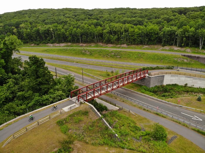 Ride the East bikers crossing the pedestrian bridge (Credit: John Bolduc)
