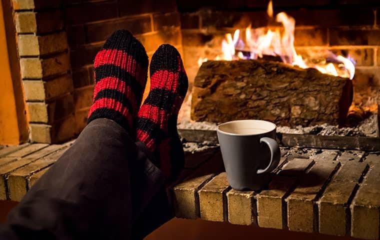 woman sitting in front of warm fireplace