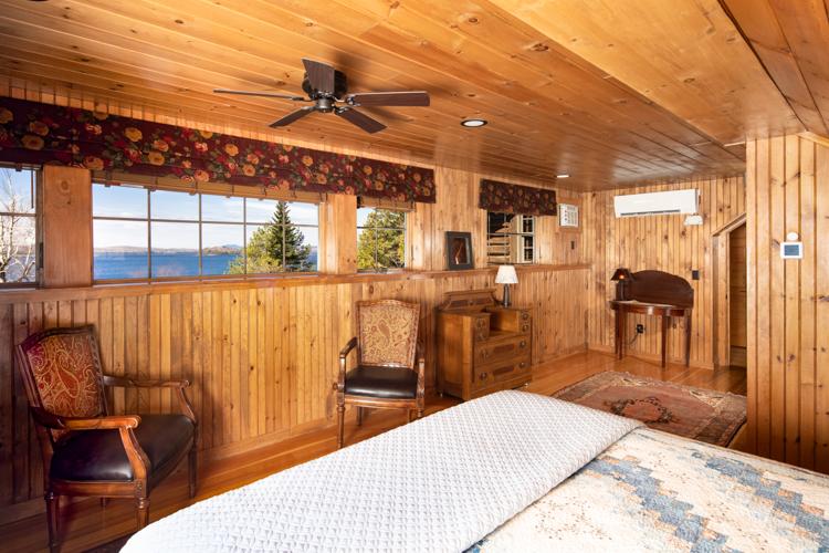 Two chairs and multiple horizontal windows in a wood paneled room