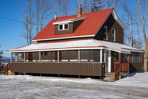 A house with a red sloped roof and brown painted walls