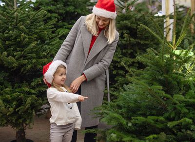 little girl and mom picking out christmas tree