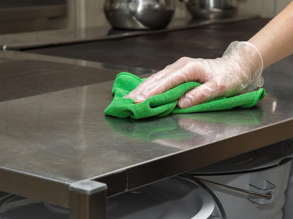 employee cleaning commercial kitchen