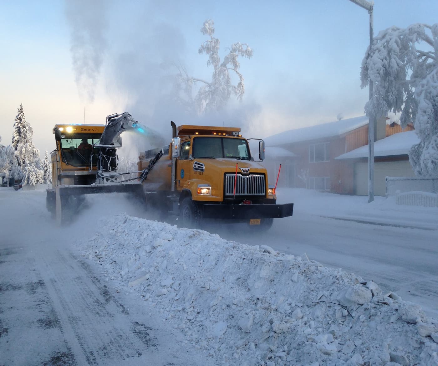 Snow blower loading a dump truck.