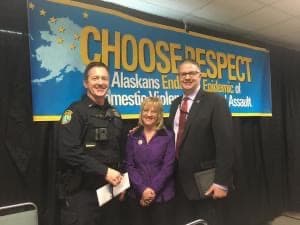 Three people standing in front of Choose Respect poster