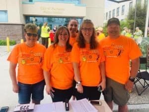 Five city employees in bright orange shirts