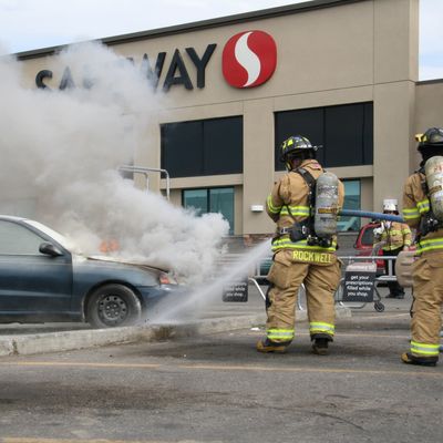Two firefighters fighting car fire