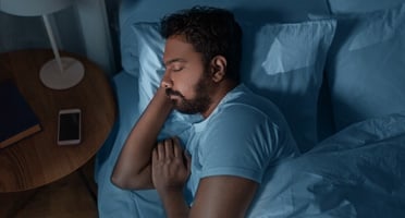 man with sleep apnea lying in bed