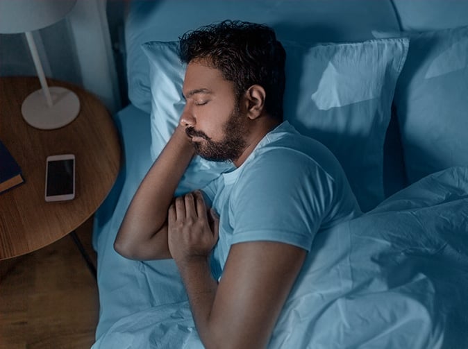 man with sleep apnea lying in bed