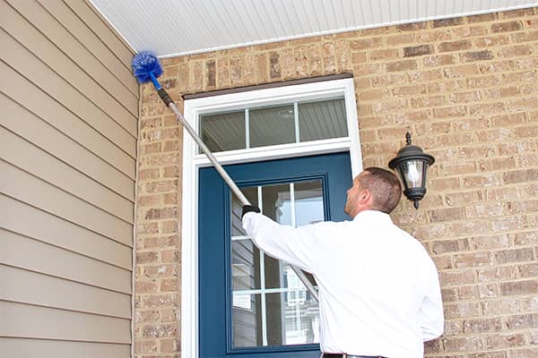 an all pest service technician treating the exterior of a home in christiansburg virginia