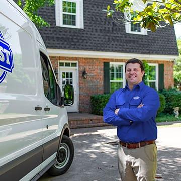 a jury pest services technician standing outside of a home in richmond county georgia