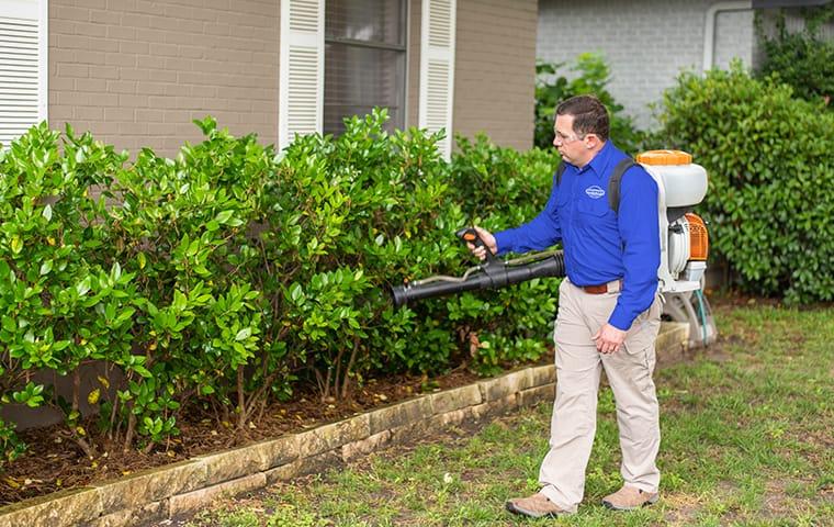 a service technician performing a mosquito treatment outside a home in aiken south carolina