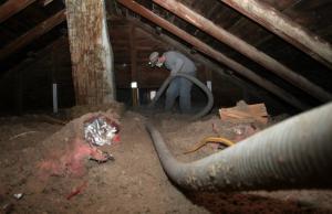 A man spraying foam insulation in an attic