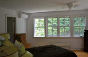 A living room with a heat pump on the wall