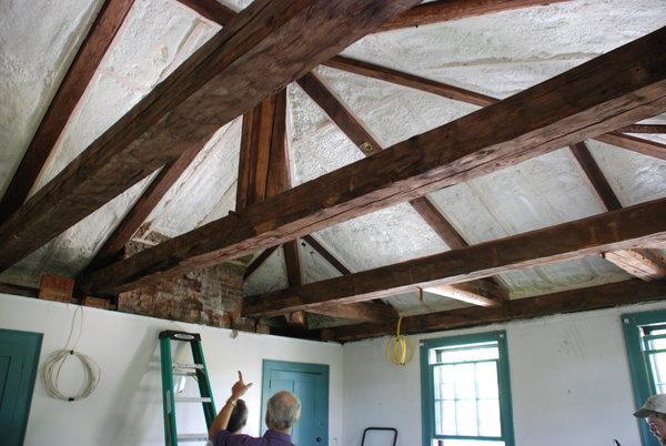 A man inspecting roof beams