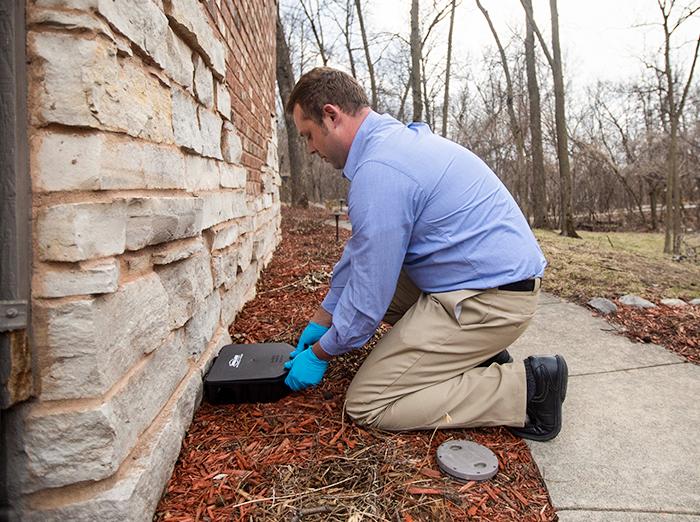 pest control specialist installing rodent control device