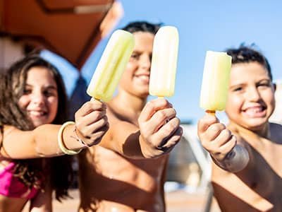kids eating popsicle by the family pool in phoenix