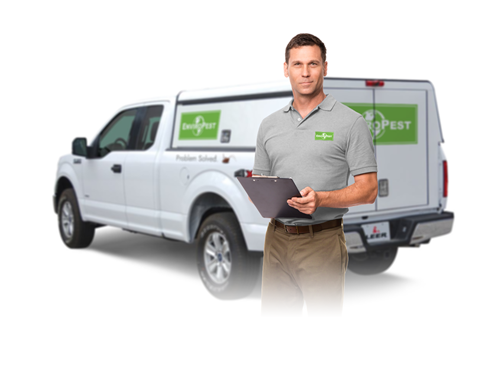 pest control service tech with clipboard in front of truck