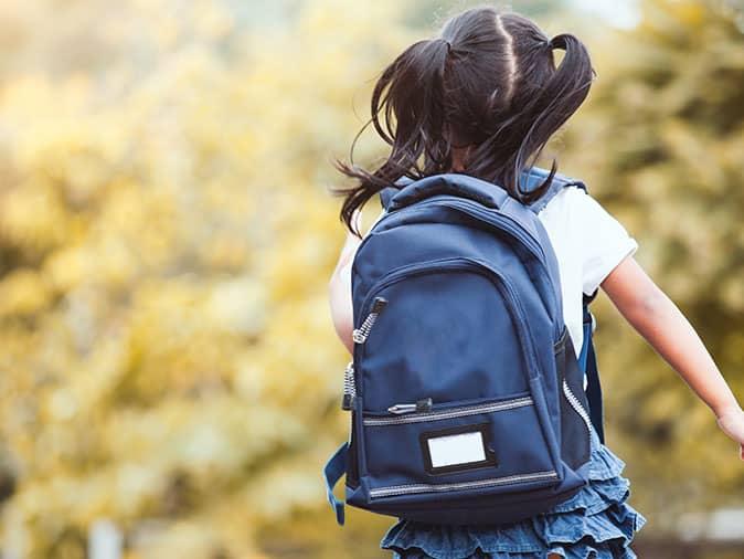 student leaving school with backpack on