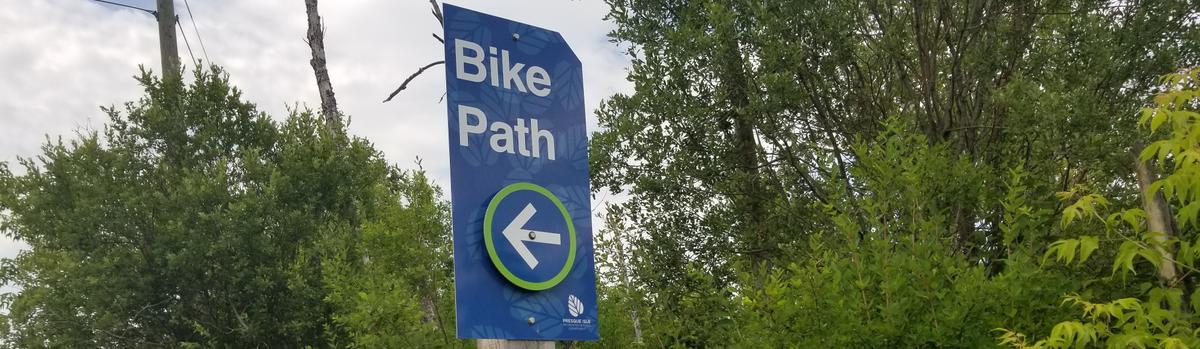 A blue sign stating Bike Path with an arrow pointing left