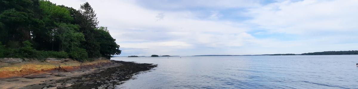 A view over a calm ocean and a rocky peninsula