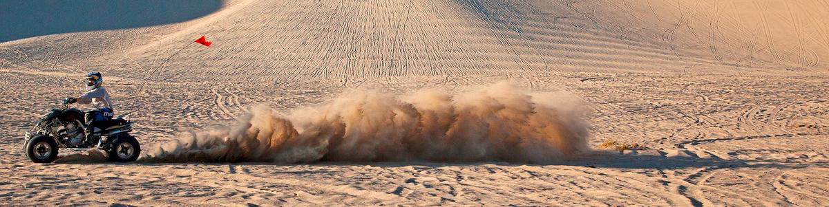 A person on an ATV drives through a playa