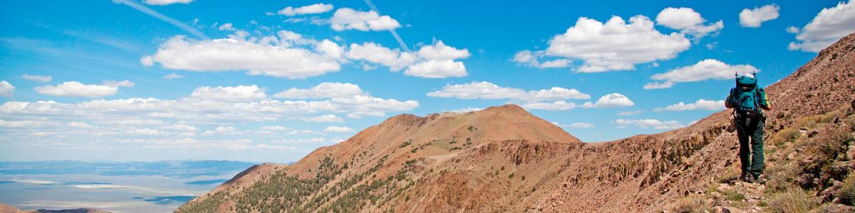 A person looks out over high elevation mountains