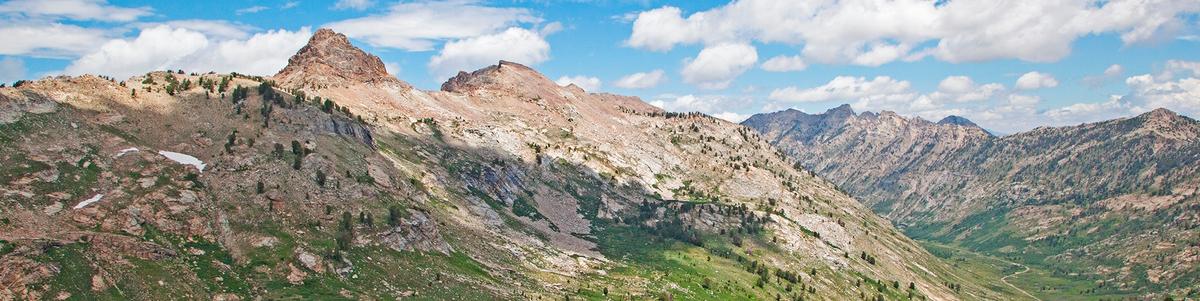 Craggy and rocky mountains over a green valley.