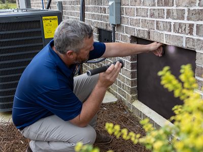 technician checking base of home