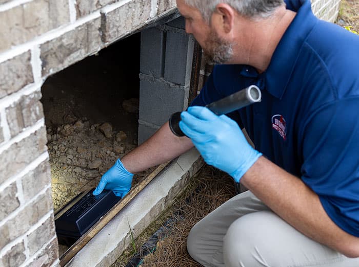 Harris pest control pro installing rodent station outside midwest home