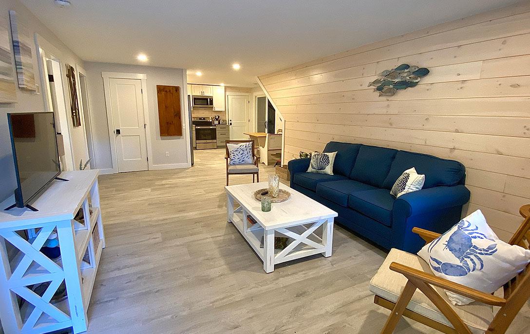 inside cabin with blue couch and white table and tvstand