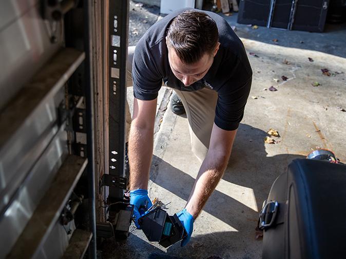 professional pest control tech installing bait in a rodent bait station in new jersey home