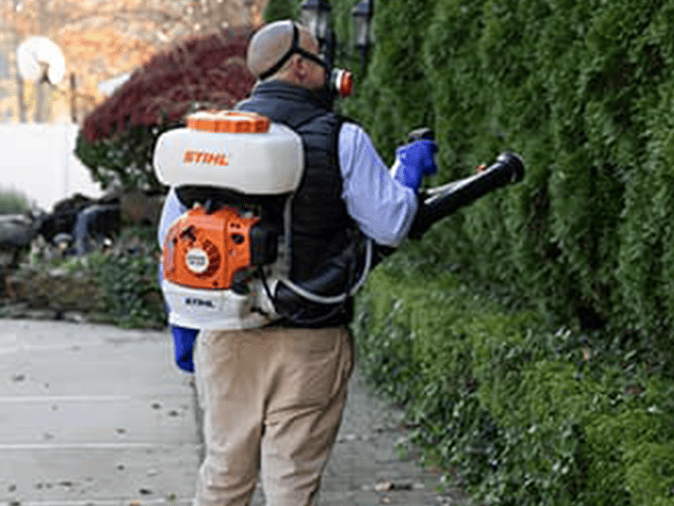 mosquito control professional performing a tick and mosquito treatment around a new jersey home