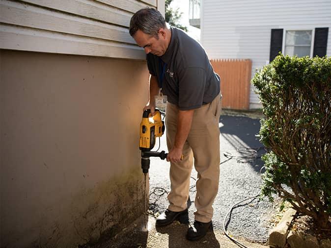 professional termite control service technician in process of termite treatment around a short hills nj home