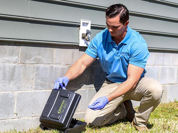pest control specialist checking rodent bait station