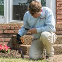 all-american pest technician checking a bait system