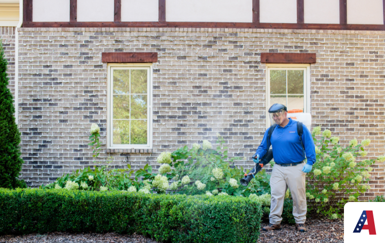 pest control technician spraying pest control