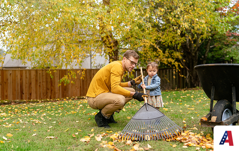 father and daughter raking leaves