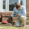 technician checking a bait station outside a home