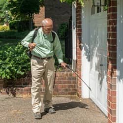 pest technician servicing the outside of a home