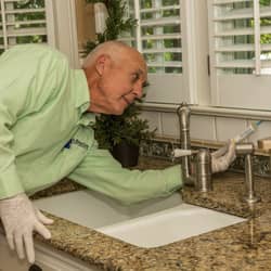 technician baiting for pests inside a home