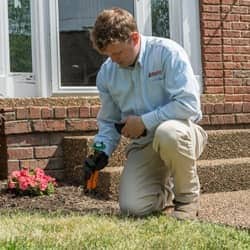 tech installing termite control outside