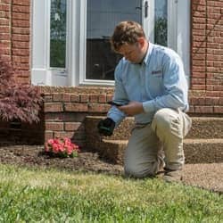 termite control technician outside a home