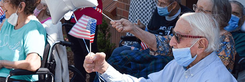 residents of blakeford waving small american flags outside