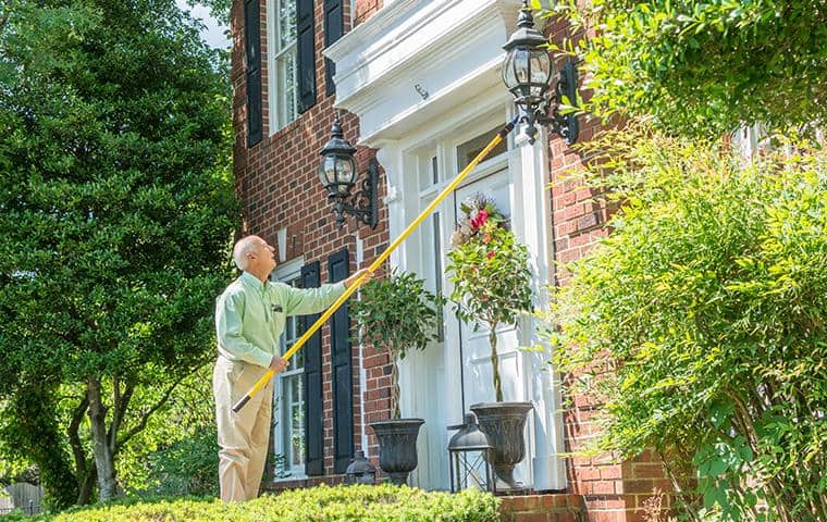 nashville pest control technician performing cobweb removal