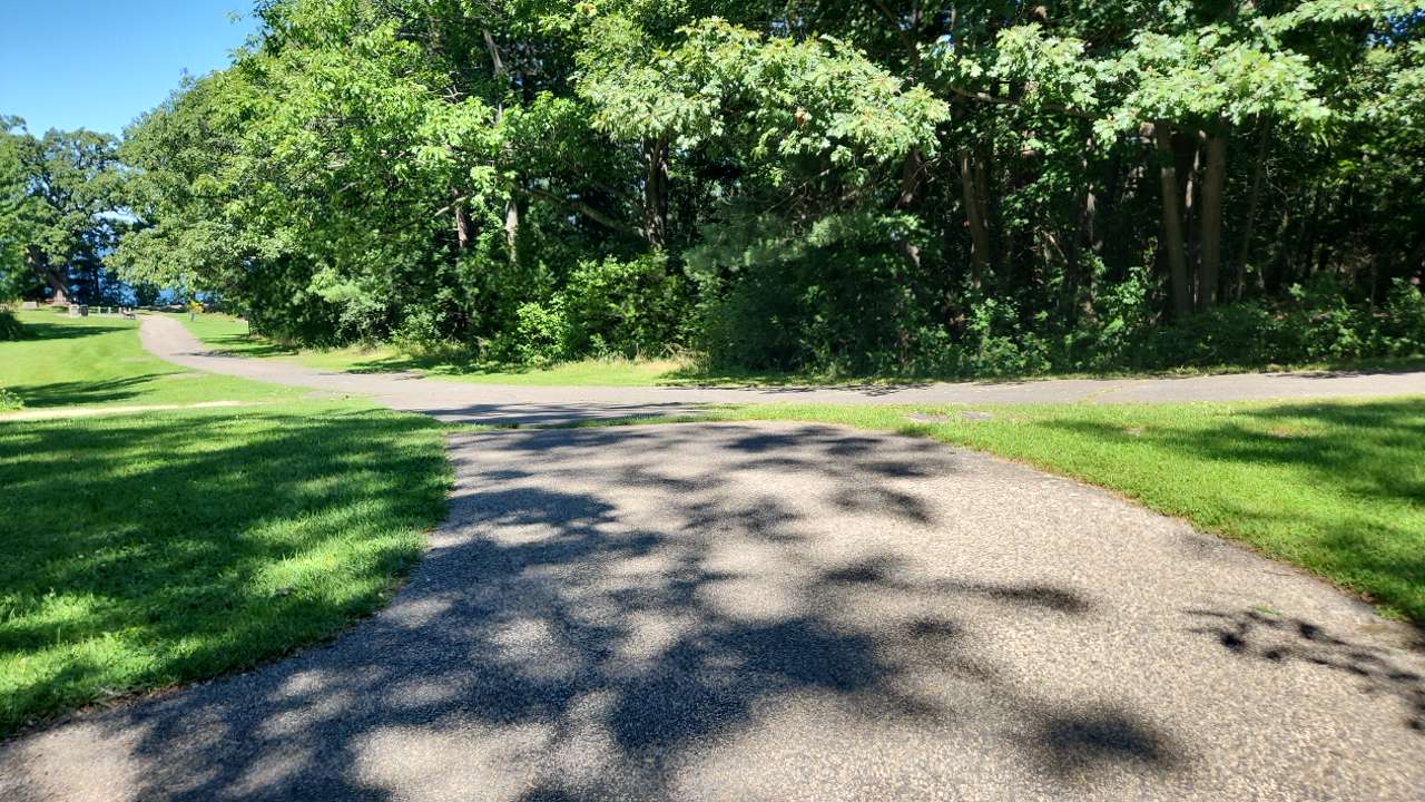 Winding gravel paths meet up between mowed grassy areas and trees behind
